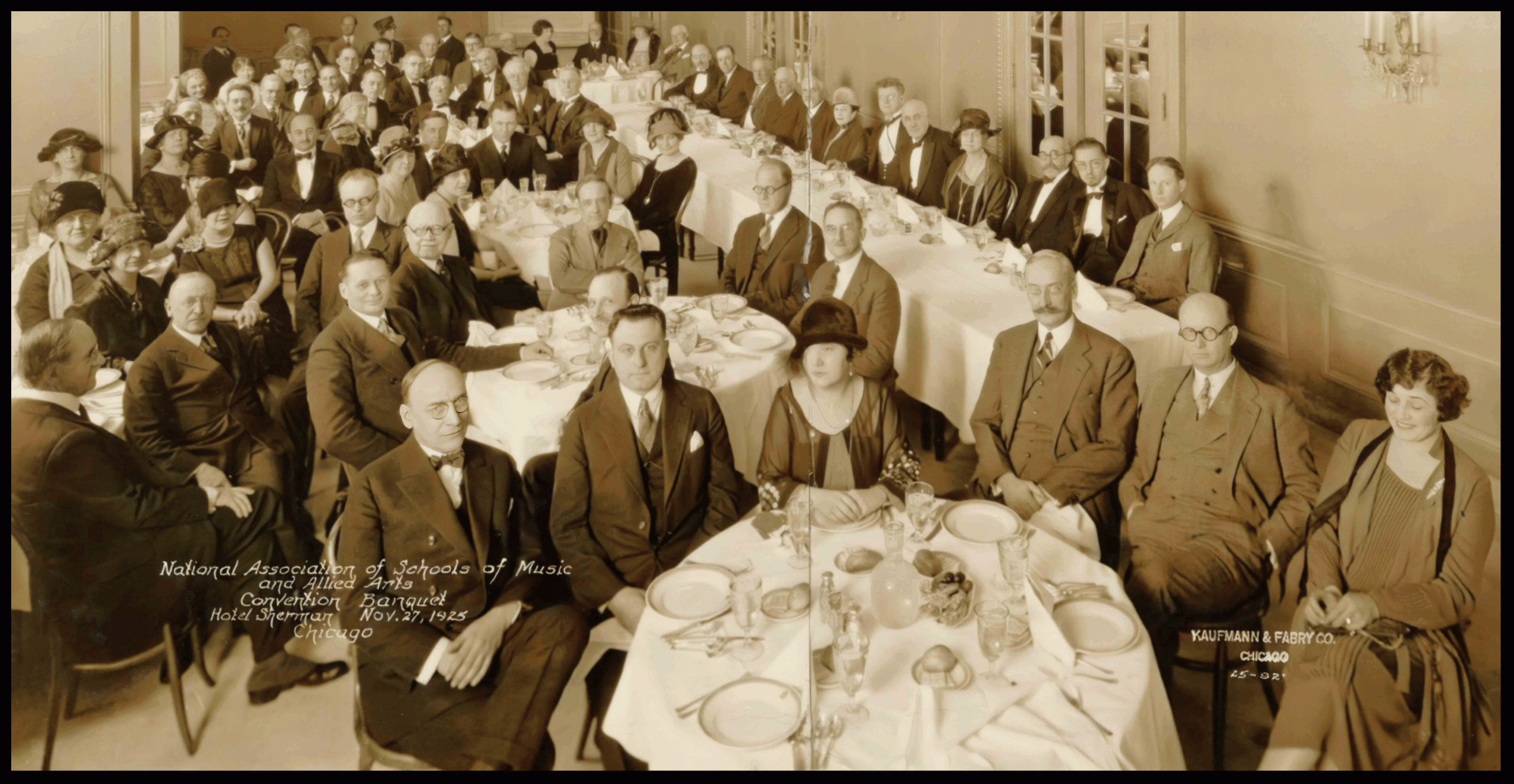 Meeting of the National Association of Schools of Music and Allied Arts Convention Banquet, Hotel Sherman, November 27, 1925, Chicago. Sepia photo of approximately 75 attendees sitting at banquet tables, facing the camera.